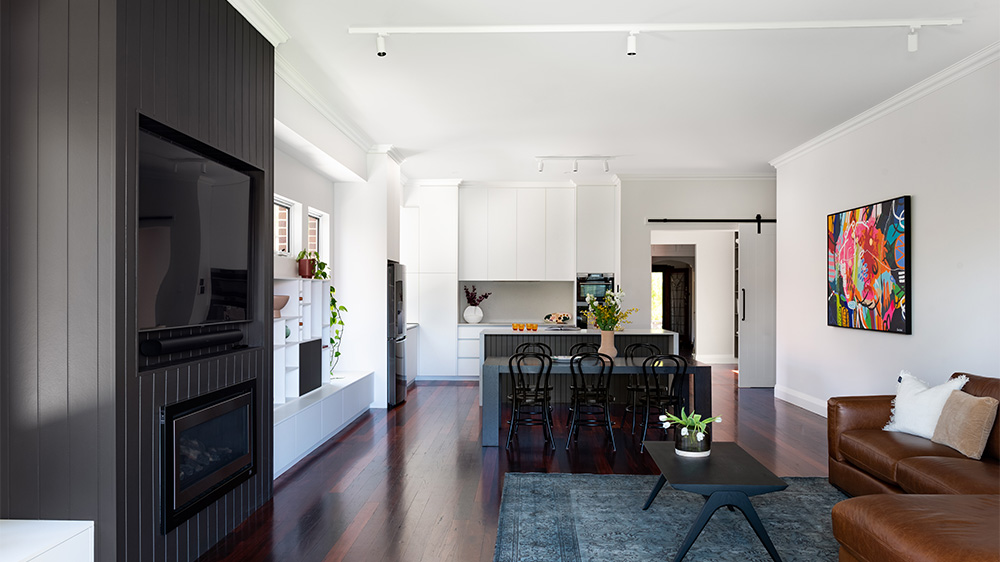 luxury open floor plan kitchen design with dark wooden floors and wooden feature wall